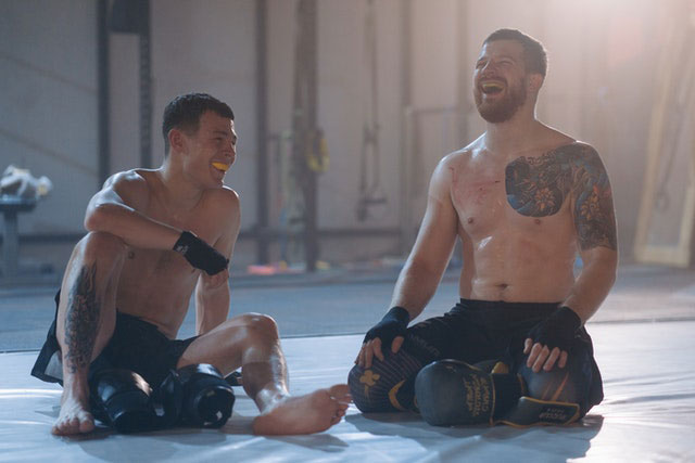 Two boxers laughing while wearing mouthguards